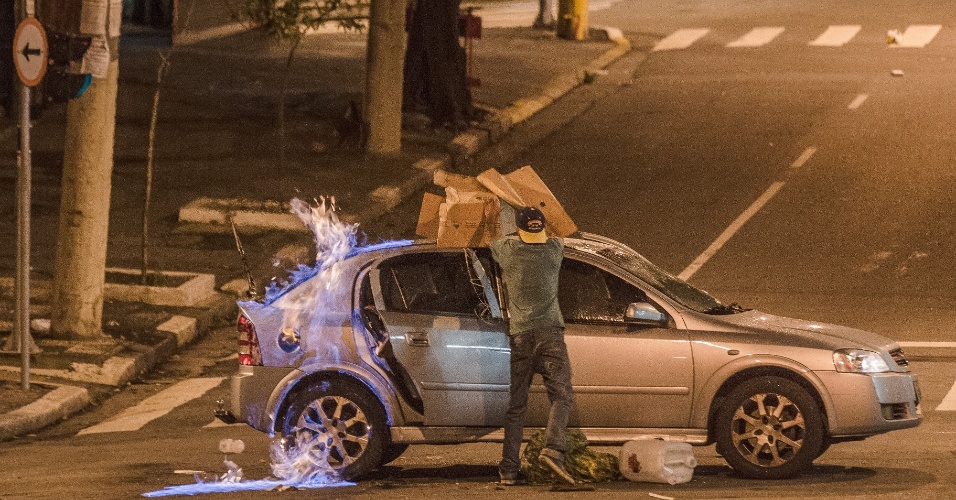 17.mar.2015 - Homem ateia fogo em carro durante confronto entre moradores do Glicério, na região central de São Paulo, com a Polícia Militar após a morte de um suspeito. Dois veículos foram incendiados