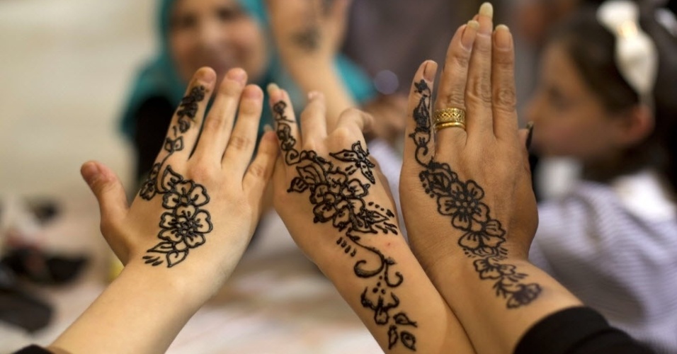 17.mar.2015 - Palestinas exibem mãos decoradas com as tradicionais tatuagens de hena durante exposição sobre o tema "os produtos de nossas mulheres", na Cidade de Gaza