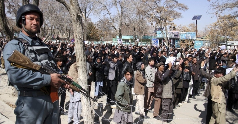 17.mar.2015 - Soldado vigia membros da comunidade hazara durante protesto contra o sequestro de 30 pessoas da minoria étnica xiita pelo Estado Islâmico, em Ghazni (Afeganistão), nesta terça-feira (17). Passageiros de dois ônibus que circulavam na província de Zabul, no sul do Afeganistão, foram sequestrados por um grupo de homens armados em 23 de fevereiro