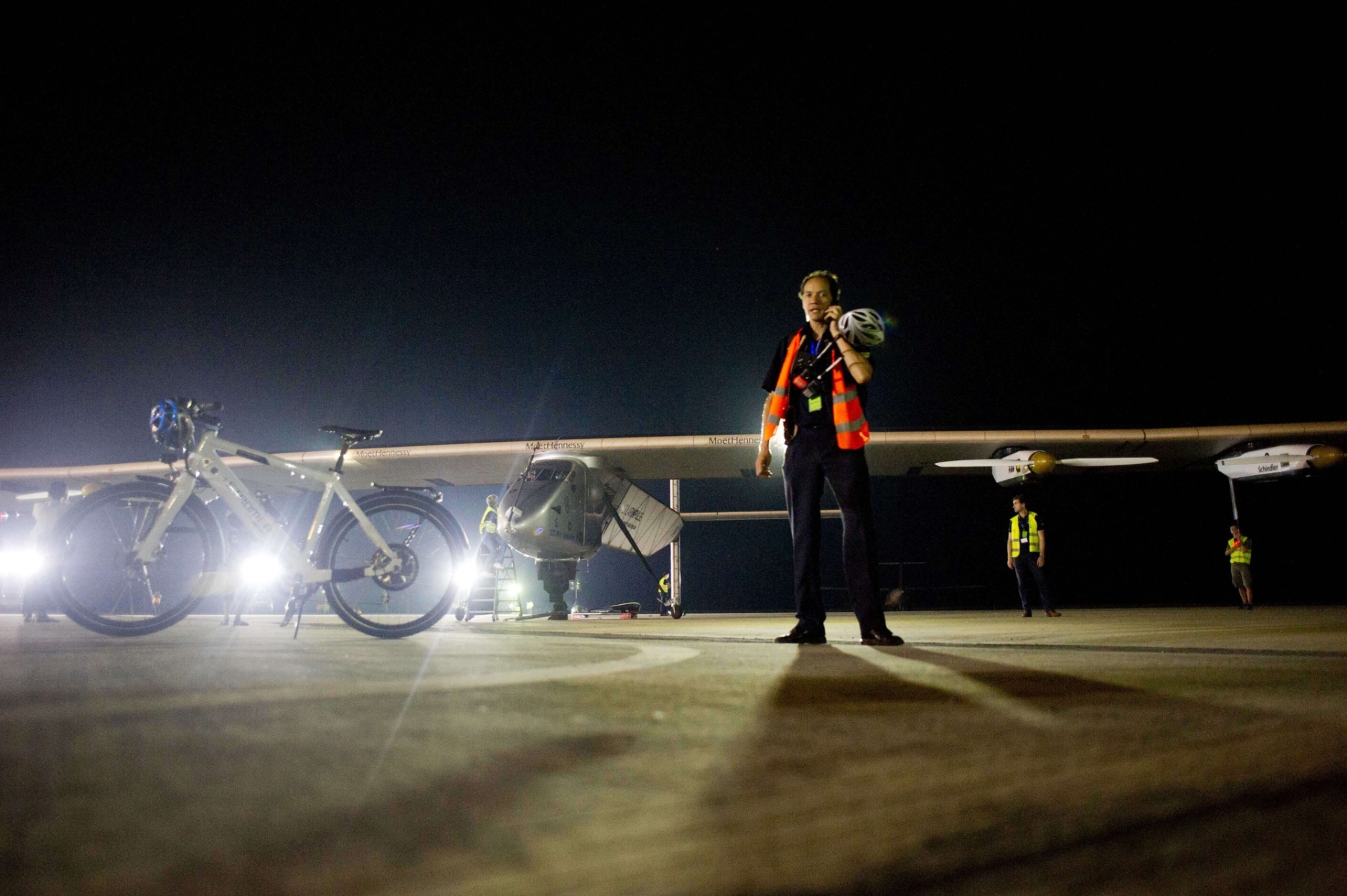 19.mar.2015 - Equipe de apoio trabalha na aterrissagem do Solar Impulse 2 no aeroporto internacional de Mandalay, a segunda maior cidade de Mianmar, nesta quinta-feira (19). O avião faz em Mianmar a sua quarta etapa de uma volta ao mundo histórica sem combustível - Ye Aung Thu/ AFP