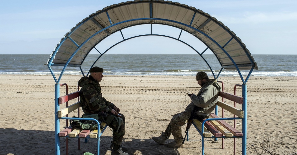 20.mar.2015 - Militares ucranianos descansam, após cavarem trincheiras, em uma praia na cidade portuária de Mar Azov nesta sexta-feira (20)