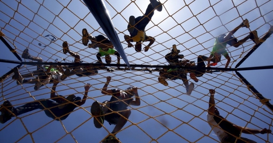 22.mar.2015 - Competidores atravessam uma rede durante uma corrida com obstáculos na Índia, no festival Desi Warrior
