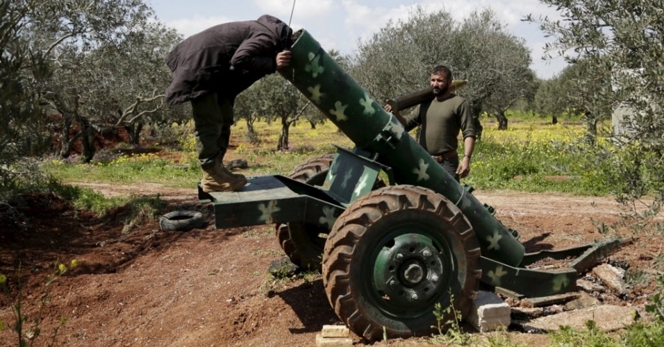 24.mar.2015 - Combatente rebelde olha dentro de um canhão na linha da frente da cidade de Idlib, no norte da Síria. A foto foi tirada em 23 de março