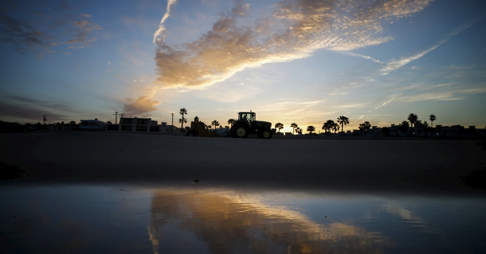 25.mar.2015 - Um trator limpa a areia da praia ao nascer do sol em Hermosa Beach, na Califórnia (EUA)