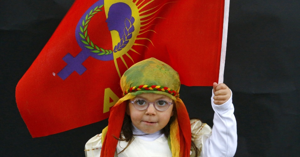 26.mar.2015 - Menina curda com bandeira chega para uma celebração em Diyarbakir, na Turquia