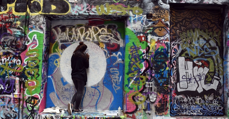 26.mar.2015 - Jovem grafita muro dentro do Rutledge Lane, em Melbourne, na Austrália