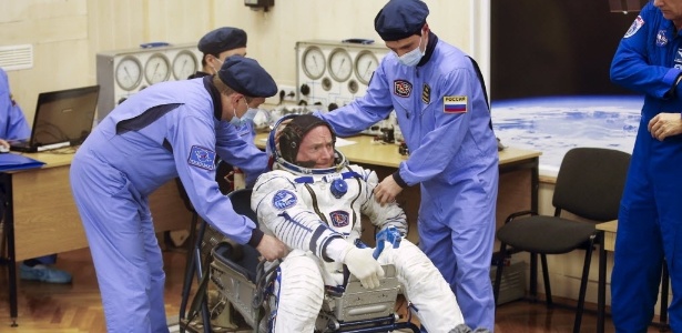 Técnicos da Nasa ajudam o astronauta Scott Kelly a vestir o traje espacial antes do lançamento  - Maxim Zmeyev/Reuters