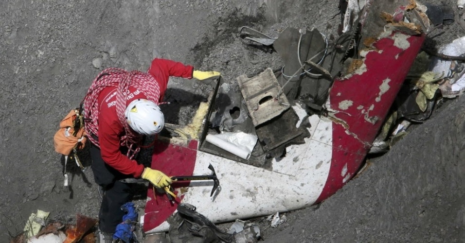 29.mar.2015 - Investigador francês inspeciona os destroços do avião da Germanwings que caiu nos Alpes franceses na terça-feira (24). A cadência de voos de helicóptero no local da tragédia diminuiu depois de a polícia conseguir isolar a área, o que facilitou os trabalhos dos investigadores