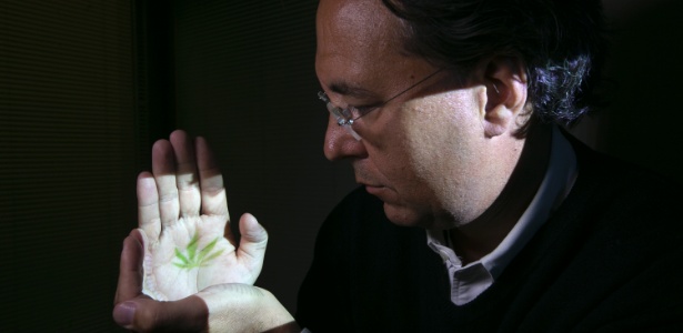 O diretor do Consórcio de Investigação de Canabinóides Canadenses Mark Ware posa com uma imagem de folha de maconha projetada sobre suas mãos - Christinne Muschi/The New York Times