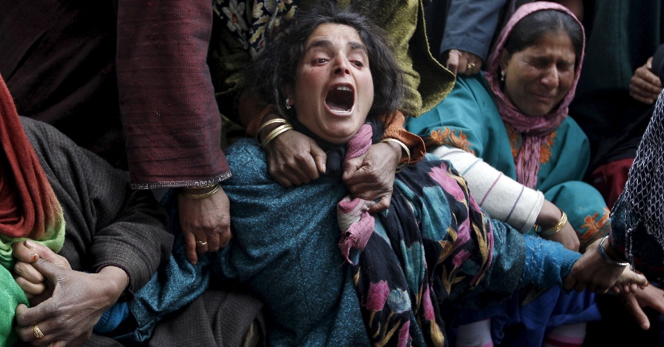 31.mar.2015 - Parentes choram durante o funeral das vítimas que morreram após uma encosta desabar sobre uma casa na vila Ledhan, oeste de Srinagar, na Caxemira (Índia)