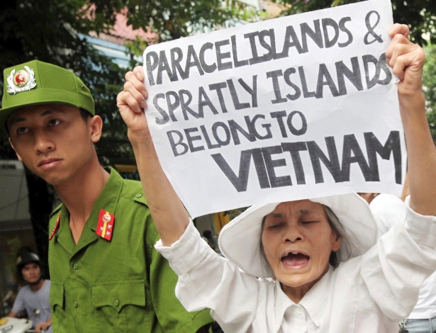 26.jun.2011 - Vietnamita participa de protesto com cartaz que declara que as ilhas Paracel e Spratly pertencem ao Vietnã, em Hanói - Luong Thai Linh/Efe