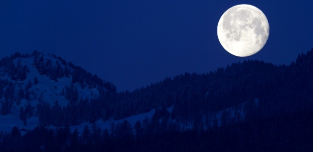 Lua cheia aparece atrás dos Alpes Suíços, vista de Charrat, no sul do país - Laurent Gillieron/Efe