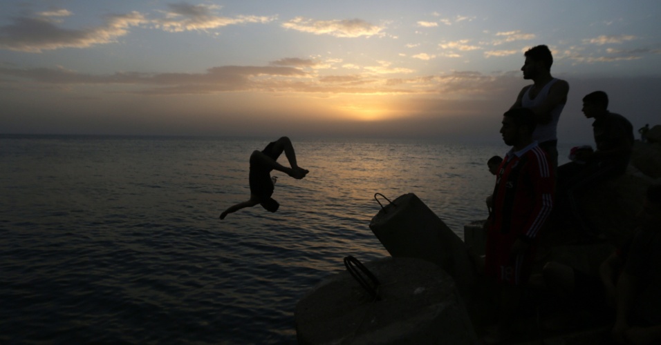 9.abr.2015 - Jovem palestino salta para o mar Mediterrâneo em um dia quente no porto na cidade de Gaza