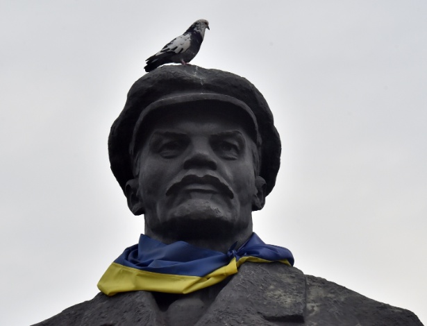 12.mar.2015 - Pombo pousa em estátua de Lênin, que têm uma bandeira da Ucrânia amarrada ao seu redor, na cidade de Slavyansk, na região de Donetsk  - Sergei Supinsky/AFP