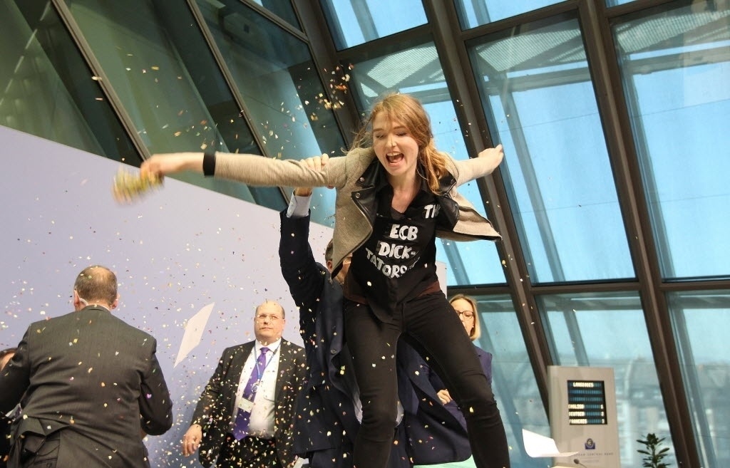Presidente do BCE (Banco Central Europeu), Mario Draghi, é atacado com confetes durante conferência - Daniel Roland/AFP