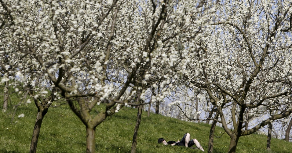 16.abr.2015 - Mulher deita na grama em dia ensolarado de primavera no Monte Petrin, em Praga, na República Tcheca