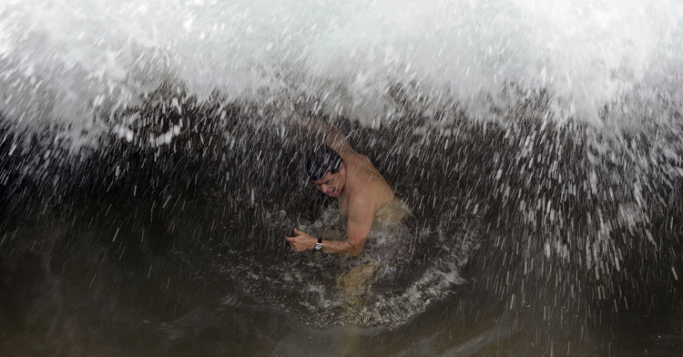 19.abr.2015 - Banhistas desafiam grandes ondas na praia de San Blas, em La Libertad, a 34 quilômetros de San Salvador, capital de El Salvador