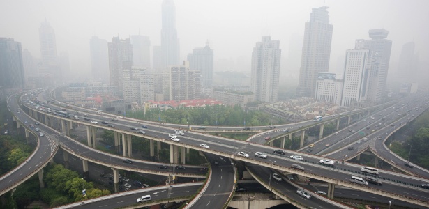  Motoristas dirigem por via elevada diante de arranha-céus em dia de muita poluição em Xangai (China) - Johannes Eisele/AFP