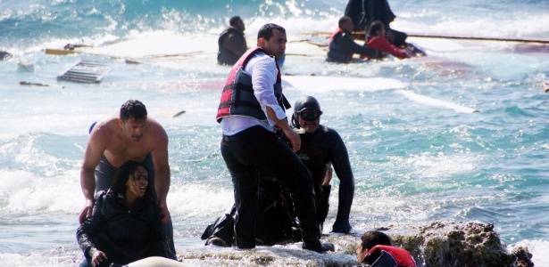 Moradores da ilha de Rodes ajudam a resgatar imigrantes que estariam a bordo de um barco que naufragou na costa da Grécia - Argiros Mantikos/AFP