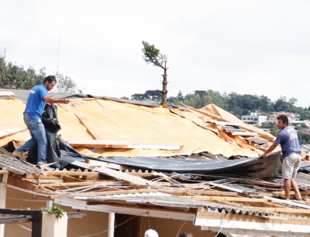 Morador de Xanxerê cobre sua casa destruída com lona - Rodrigo Vargas/Raw Image/Estadão Conteúdo