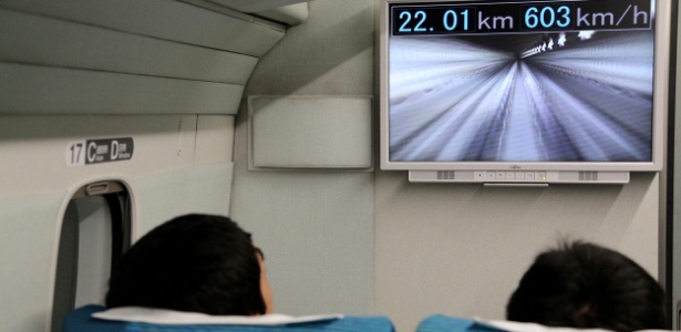 Passageiros viajam em trem-bala Maglev japonês enquanto monitor exibe a velocidade alcançada - Jiji Press/AFP