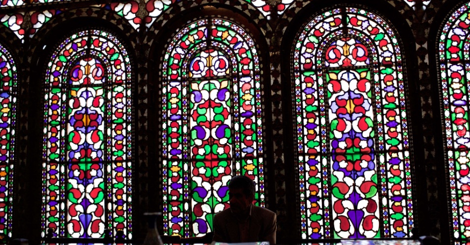 22.abr.2015 - Um homem se senta em frente aos vitrais de uma casada dinastia Qajar, que foi convertida em um hotel na cidade histórica de Isfahan, no Irã