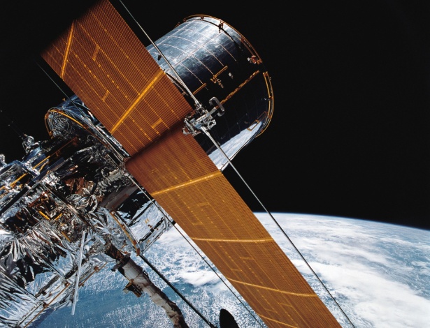 O Telescópio Espacial Hubble é fotografado suspenso pelo Sistema Manipulador Remoto (RMS, na sigla em inglês) a partir da nave espacial Discovery, em 25 de abril de 1990. Lançado em abril de 1990, o Hubble completa 25 anos e nesse período teve um papel fundamental nos avanços da pesquisa científica espacial - Xinhua/Nasa/Zumapress