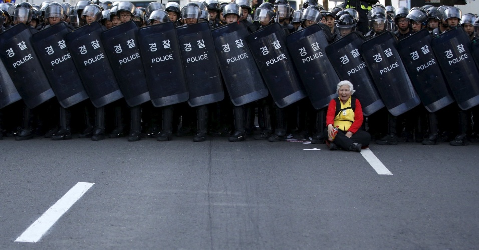24.abr.2015 - Uma manifestante idosa se posiciona em frente a uma barricada de policiais durante um protesto em Seul, na Coreia do Sul