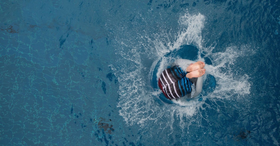 27.abr.2015 - Jovem mergulha em piscina pública durante um evento para promover piscinas ao ar livre em Berlin, na Alemanha