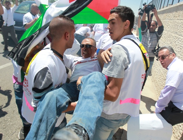 2.mai.2015 - Palestinos carregam homem ferido em confronto com o Exército israelense durante protesto por liberdade de imprensa, em Belém da Cisjordânia - Musa Al Shaer/AFP