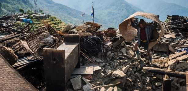 Homem procura por seus pertences em meio aos escombros em vila de Barpak, no Nepal. Por conta da pouca acessibilidade, avaliar os danos e contar o número de vítimas é bastante difícil - Daniel Berehulak/The New York Times