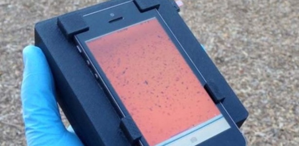 Aparelho que funciona como "microscópio portátil" é acoplado no iPhone e, com o uso da câmera, ele detecta quantidade de parasitas no sangue  - Reprodução
