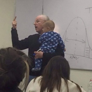 O professor Sydney Engelberg segura no colo bebê de estudante - Reprodução/Facebook