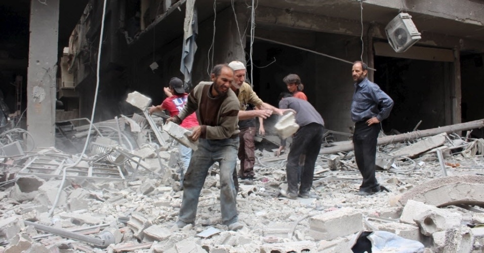 14.mai.2015 - Civis removem escombros de um local destruído após ataques aéreos de forças leais a ditador sírio Bashar Assad, em Damasco, Síria 