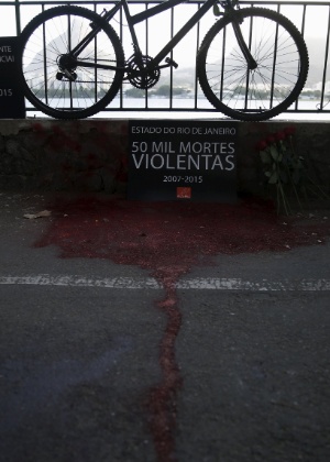 Ativistas da ONG Rio de Paz usaram tinta vermelha para simular sangue diante de uma bicicleta durante protesto pela morte do médico - Pilar Olivares/Reuters
