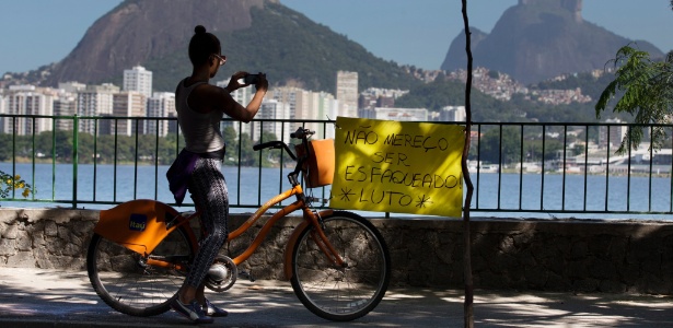 Ciclista tira foto de cartaz afixado em protesto contra a violência na Lagoa (RJ). "Não mereço ser esfaqueado." - Agência O Globo