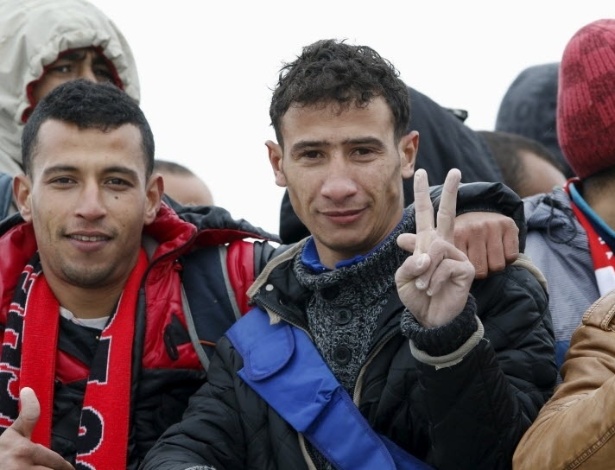 O marroquino Abdelmajid Touil (direita) acena ao lado de outros imigrantes dentro de um navio da Marinha italiana - Antonio Parrinello/Reuters