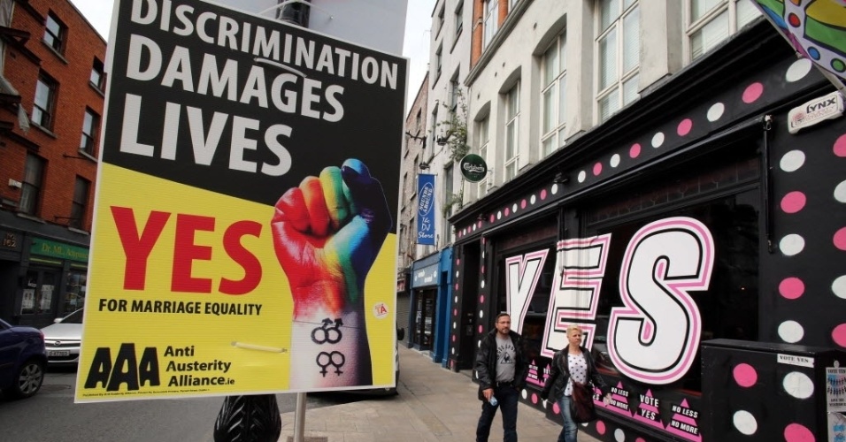 22.mai.2015 - Pedestres caminham entre cartazes em favor do casamento entre pessoas do mesmo sexo em Dublin, capital da Irlanda. Nesta sexta-feira (22), o país realiza um referendo para decidir sobre a legalidade do casamento entre pessoas do mesmo sexo