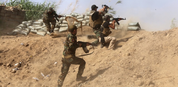 Combatentes sunitas iraquianos que lutam ao lado das forças de segurança do governo entram em confronto jihadistas nos arredores da refinaria de petróleo de Baiju, a 200 km ao norte de Bagdá, no Iraque, na última segunda-feira (25) - Ahmad al-Rubaye/AFP