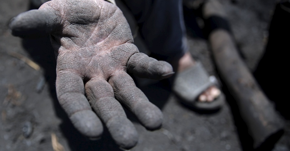 26.mai.2015 - Trabalhador com 70 anos de idade mostra sua mão em uma fábrica de carvão vegetal tradicional em uma aldeia em Qaha, perto do Cairo, no Egito