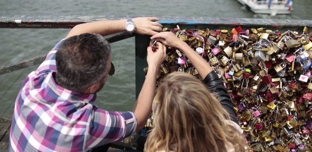 Casal coloca um cadeado na Pont des Arts, em Paris, na França - Charly Triballeau/AFP 