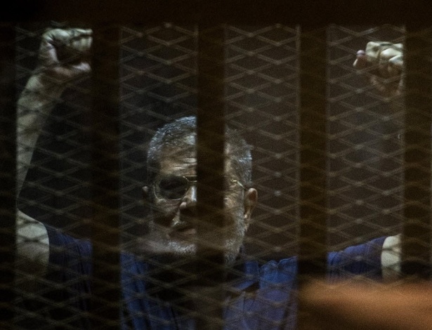 O ex-presidente egípcio Mohamed Mursi é colocado em cela enquanto assiste a julgamento no Cairo - Khaled Desouki/AFP