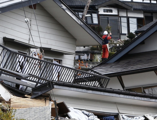 23.nov.2014 - Bombeiro inspeciona casas que desabaram após um forte terremoto, em Hakuba, Nagano (Japão) - Jiji Press/AFP