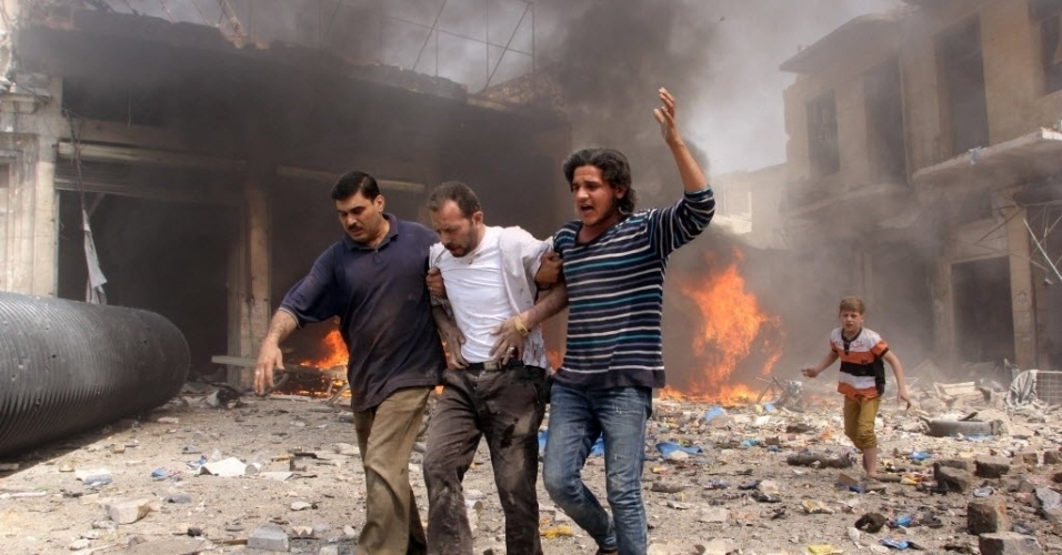 3.jun.2015 - Homens ajudam um ferido após um atentando feito por forças leais ao ditador sírio Bashar Assad, em Aleppo, Síria. Pelo menos 24 pessoas morreram, entre elas oito crianças, durante os bombardeios desta quarta-feira (3)