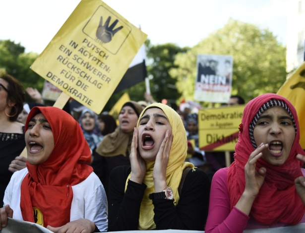 3.jun.2015 - Jovens muçulmanas protestam contra a visita do ditador do Egito, Abdel Fattah al-Sisi, a Berlim; cartaz diz "Golpe no Egito - um severo retrocesso para a democracia" - Odd Andersen/AFP