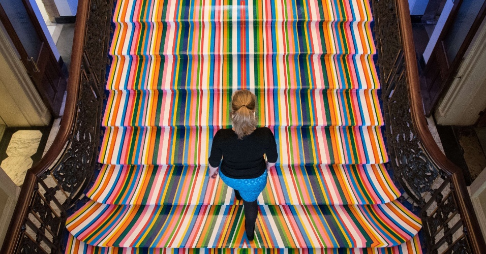 3.jun.2015 - Funcionário da Academia Real de Artes caminha sobre instalação do artista britânico Jim Lambie, "Zobop", durante a exposição Royal Academy Summer Exhibition, em Londres, no Reino Unido