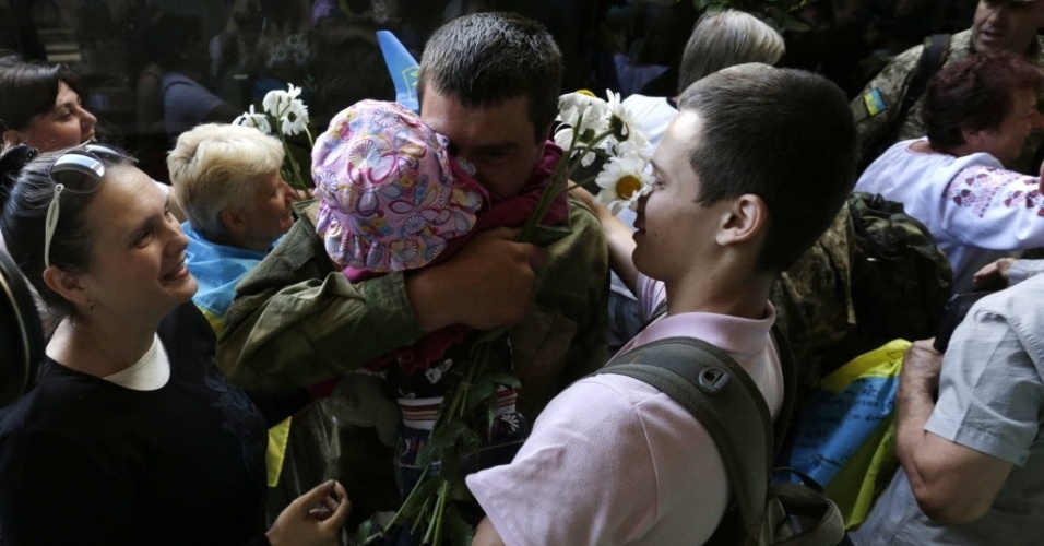 5.jun.2015 - De volta de Donetsk, onde o Exército da Ucrânia enfrenta rebeldes pró-Rússia, soldado ucraniano é abraçado por familiares em estação de trem em Kiev, capital do país