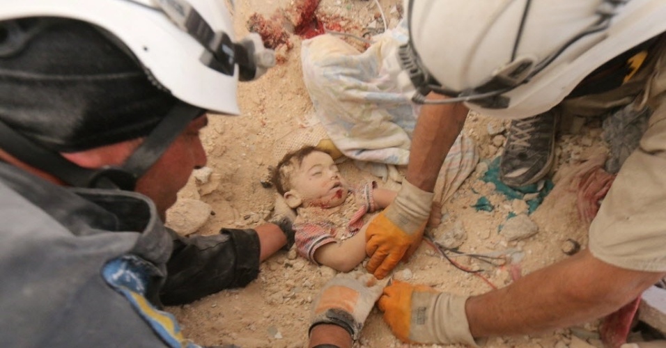 5.jun.2015 - O corpo de um bebê é resgatado de ruínas de casa bombardeada por forças sírias em Aleppo, no norte da Síria, nesta sexta-feira (5). Três membros de uma família, o pai, a mãe e a criança, morreram no bombardeio