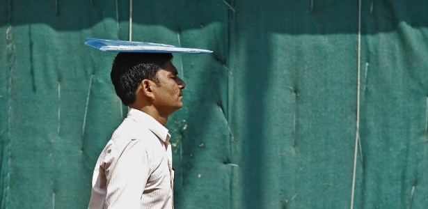 8.jun.2015 - Homem coloca pasta sobre a cabeça para se proteger do sol forte em Nova Déli, capital da Índia. A onda de calor, com temperaturas de até 50ºC, matou milhares de pessoas neste ano - Adnan Abidi/Reuters
