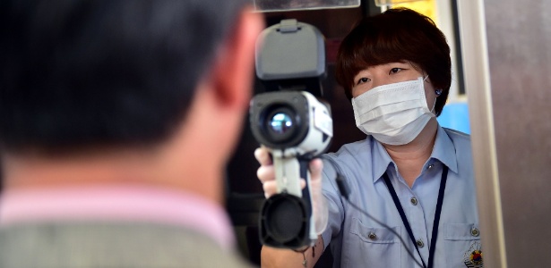 Funcionário verifica neste sábado (13), com câmera térmica, a temperatura de ministro sul-coreano em visita ao centro alfandegário de Paju - Jung Yeon-Je/AFP